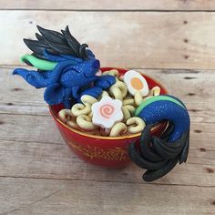 a toy dragon sitting in a cup filled with cereal