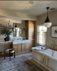 a bath room with a tub a sink and a mirror on the wall next to a window