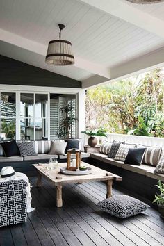 an outdoor living room with black and white furniture