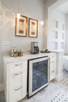 a bathroom with a sink, toilet and bathtub in the corner next to two framed pictures on the wall