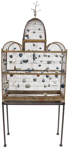 a bird cage sitting on top of a metal stand