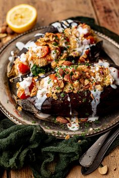 an eggplant covered in yogurt and other toppings on a plate