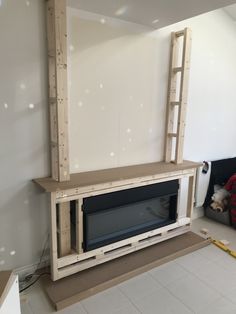 a fireplace being built in the corner of a room with white walls and flooring