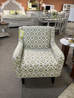 an upholstered chair is on display at a furniture store with other chairs and tables in the background