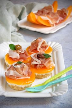 small appetizers with meat and cheese on them are sitting on a white plate