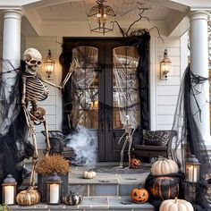 a porch decorated for halloween with skeletons and pumpkins