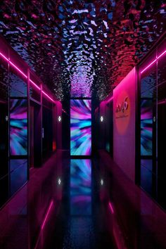 an empty hallway is lit up with neon lights and confetti on the ceiling