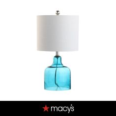 a blue glass table lamp with a white shade on the bottom and an inscription macy's above it