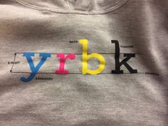 the word yrbk is written in multicolored letters on a gray t - shirt