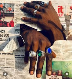 two hands with rings on top of newspaper