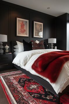 a bed with red fur on top of it next to two framed pictures and lamps