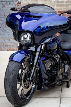 a blue motorcycle parked on top of a sidewalk