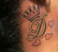 a man with a tattoo on his neck has a crown and hearts behind the ear