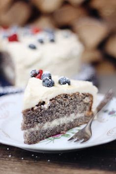 a slice of cake with white frosting and berries on it