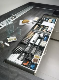 an organized kitchen drawer with utensils and spoons in it on a countertop