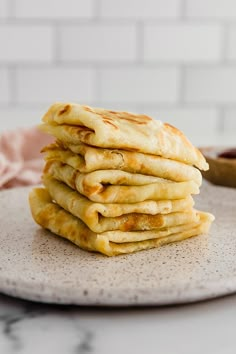 a stack of pancakes sitting on top of a white plate