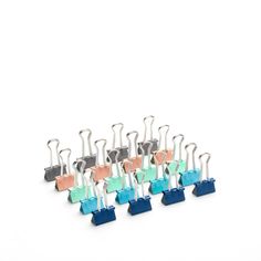 a bunch of different colored clips sitting next to each other on a white surface in front of a white background