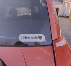 a red car with the words drive safe on it's side window and an i love heart sticker