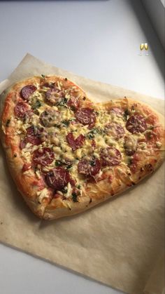 a heart shaped pizza sitting on top of a piece of paper