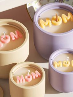 three small containers with the word mom spelled out in pink, yellow and purple letters