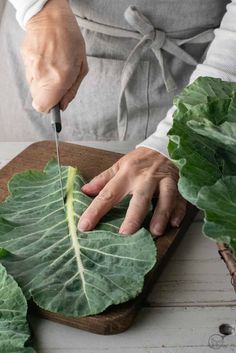 a person cutting up a leaf on a cutting board with the words how to cut and clean collard greens