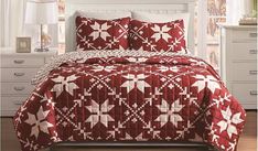 a red and white quilted bed in a bedroom