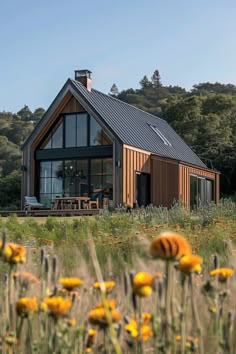 a house in the middle of a field with yellow flowers