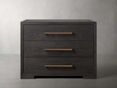 a wooden dresser with three drawers and brass pulls on the bottom, against a gray background