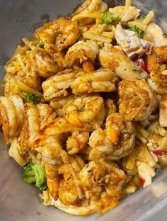 a bowl filled with shrimp, broccoli and pasta mixed in it's sauce