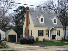 a car parked in front of a yellow house