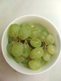 green grapes in a white bowl on a table