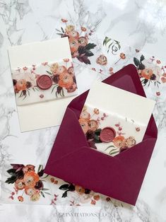 two envelopes with flowers on them and one has a button in the middle that says congratulations