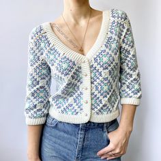 a woman with short hair wearing a sweater and jeans