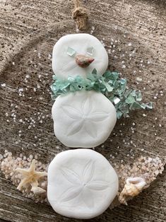 Dress up your Christmas Tree Coastal- style with this cute Snowman! The aqua crushed glass COASTAL SNOWMAN   features sand dollars, tiny seashells and starfish and is set in resin with a snowy background on a sandy BEACH.  The Snowman is set on  a  clear acrylic 4" round ornament. Twine hanger makes it easy to place on your tree! Perfect as a sun catcher too!!  Price is for one Snowman   ornament. Order yours today ! Thank you for visiting Sea Dreams!  Happy Holidays! Christmas Seashell Ornaments, Crushed Glass Ornaments, Coastal Christmas Decor Ideas, Shell Snowman Ornaments, Sea Shell Snowman, Sand Dollar Xmas Ornaments, Seashell Ornaments Diy Coastal Christmas, Sand Dollar Decor, Sand Dollar Snowman Ornament