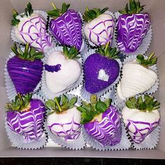 chocolate covered strawberries in a box with white frosting and purple swirls on them