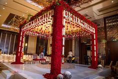 an elaborately decorated stage with red flowers and balls on the floor in front of it