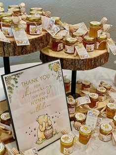 there are many honey jars on the table with thank you cards and signs in front of them