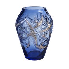 a blue glass vase with silver birds on the rim and bottom, sitting in front of a white background