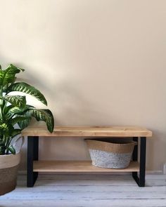 a potted plant sitting on top of a wooden table next to a shelf with a basket