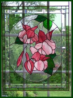 a stained glass window with pink flowers in the center and green leaves on it's side