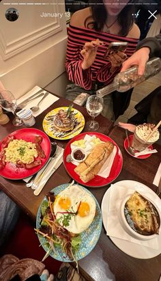 a woman sitting at a table filled with plates of food