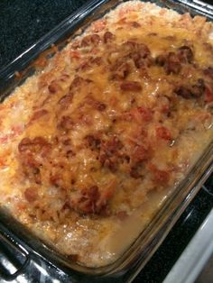 a casserole dish with meat and cheese in it sitting on a stove top