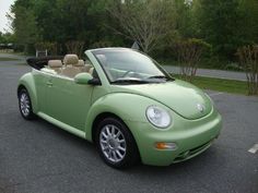 a green convertible car parked in a parking lot