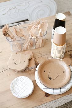 a wooden table topped with plates and utensils