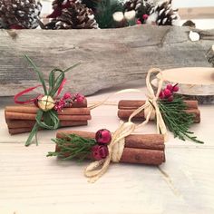 cinnamon sticks tied with twine and decorated with berries, greenery and pine cones