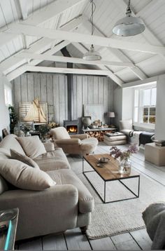 a living room filled with furniture and a fire place in the middle of a room