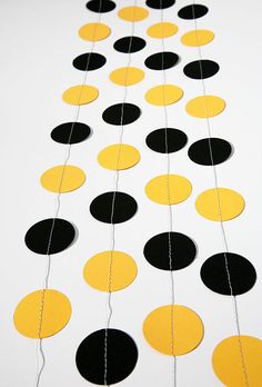 black, yellow and white circles are hanging from a string