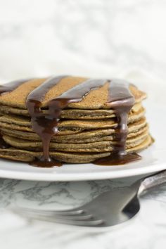 a stack of pancakes with chocolate drizzled on top