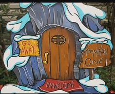 a wooden sign that says welcome to an ice - covered house with snow on the roof