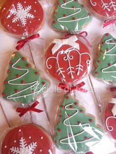 decorated cookies in the shape of christmas trees and snowflakes are displayed on sticks